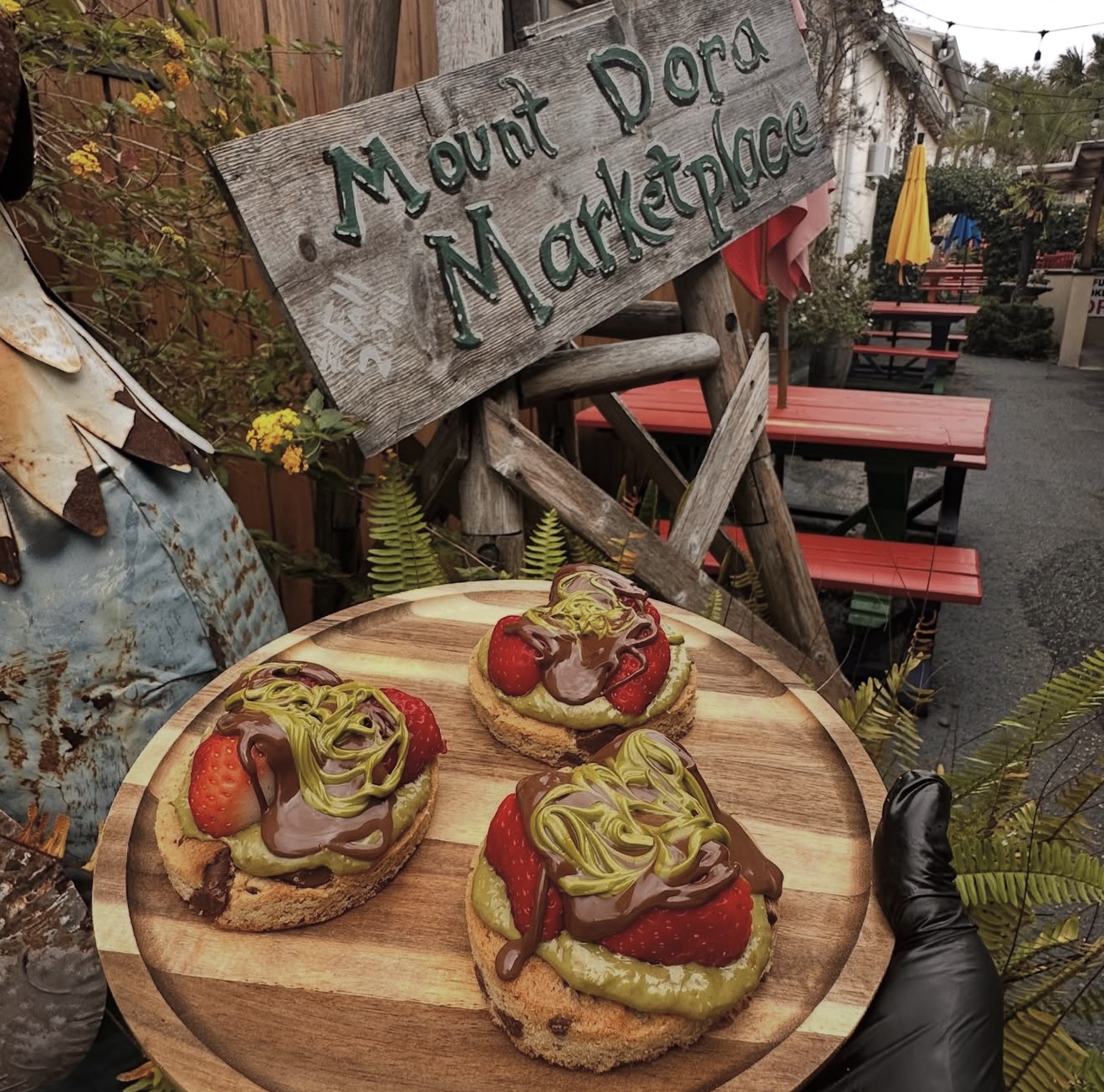 Open-faced cookies topped with pistachio cream, fresh strawberries, and chocolate drizzle
